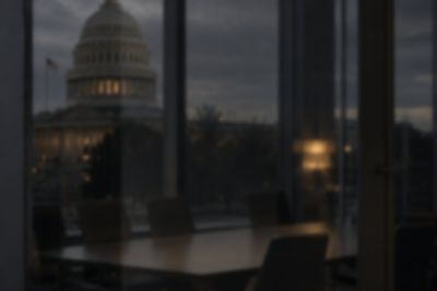 The U.S. Capitol at dusk seen through the window of a boardroom in Washington, D.C.